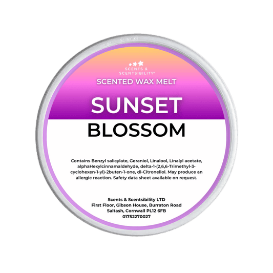 Scented wax melt tin labeled 'Sunset Blossom' on a green background