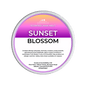 Scented wax melt tin labeled 'Sunset Blossom' on a green background