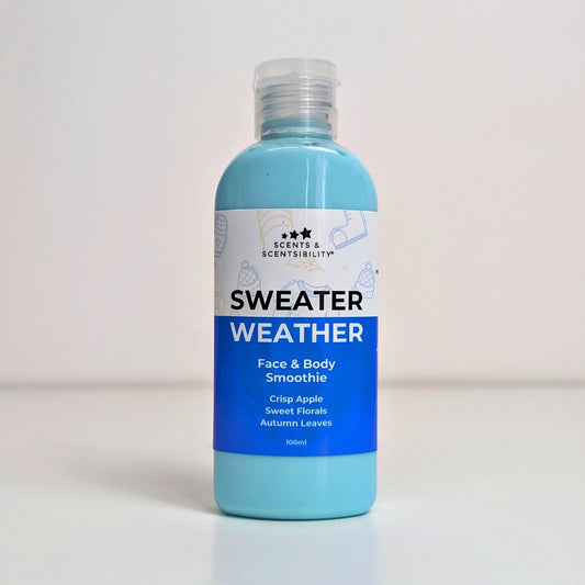 Blue bottle of 'Sweater Weather' face and body smoothie body lotion with a label on a light grey background