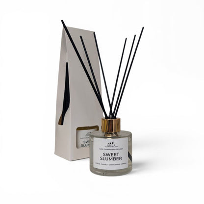 Diffuser bottle labeled 'Sweet Slumber' with black sticks on a white background