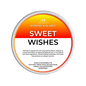 A Scents & Scentsibility 'Sweet Wishes' scented wax melt, featuring a white label with a vibrant orange-to-yellow gradient top section and black text, set against a solid dark green background.