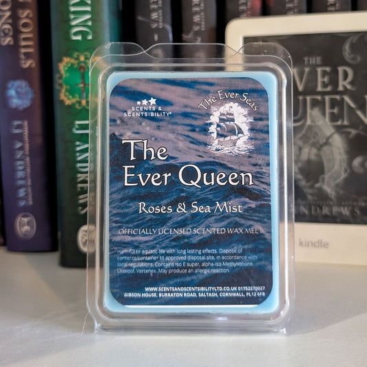 Scented wax melt packaging labeled 'The Ever Queen' with books in the background