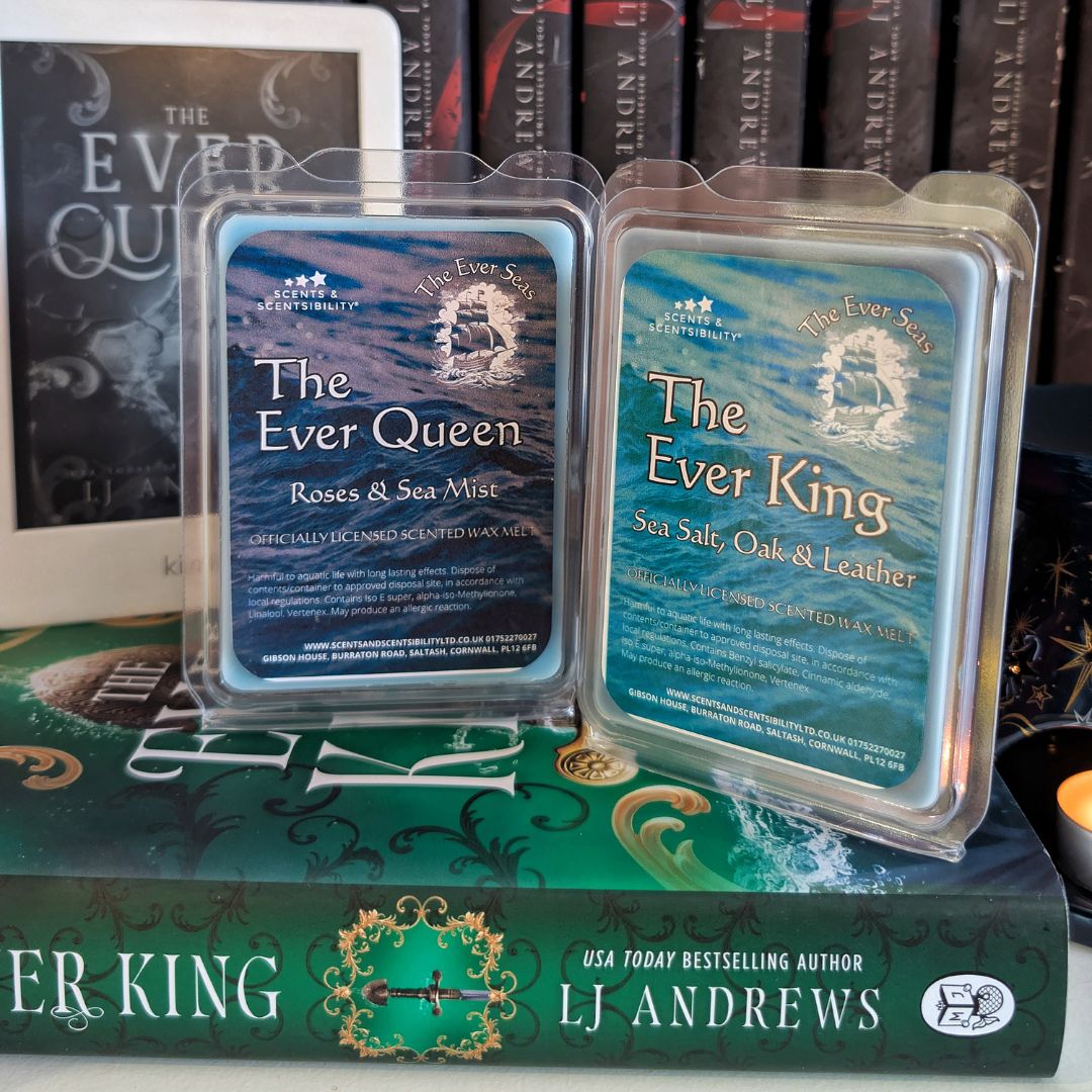 Two wax melts clams labeled 'The Ever King' and 'The Ever Queen' on top of a book titled 'The Ever King' by LJ Andrews.