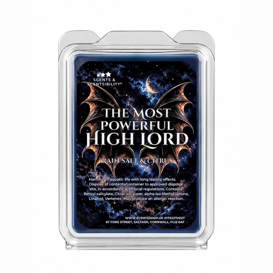 A clear plastic clamshell wax melt container on a white background, showing a dark blue label with a cosmic wings design and the text 'THE MOST POWERFUL HIGH LORD' and 'RAINS, SALT & CITRUS'.