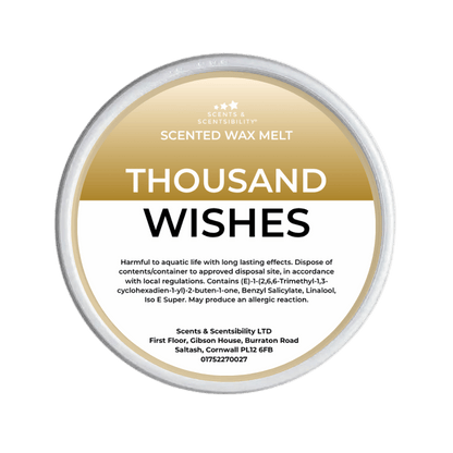 Scented wax melt container labeled 'Thousand Wishes' on a green background