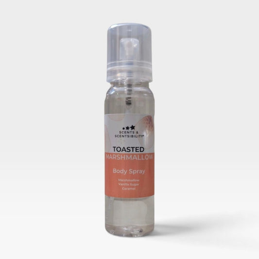 A clear plastic pump bottle of Scents & Scentsibility 'Toasted Marshmallow' body spray, showing a clear liquid inside, set against a plain light gray background.