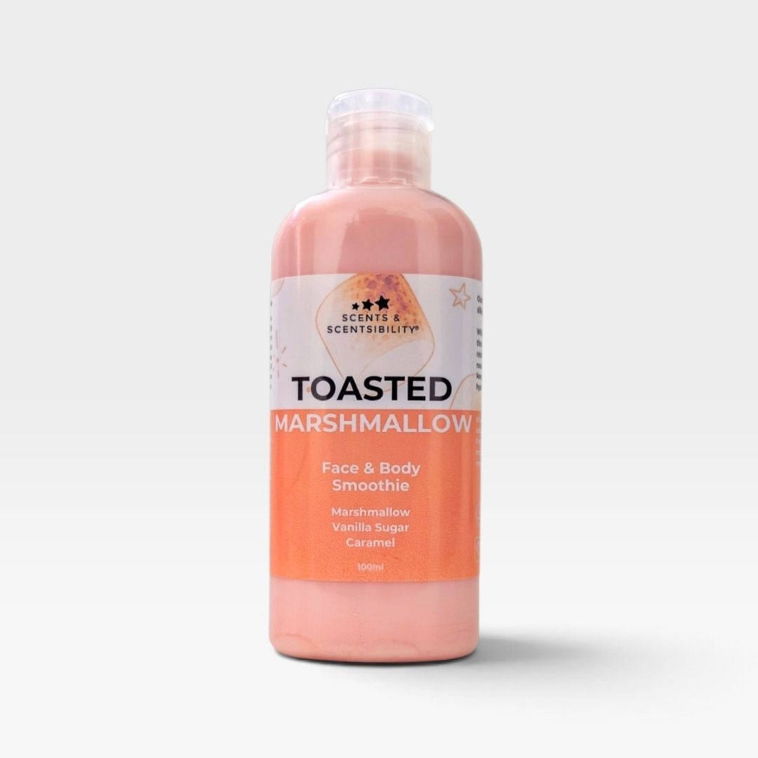 A 1000ml bottle of Scents and Scentsibility Toasted Marshmallow Face & Body Smoothie, featuring a peach-colored liquid and a white and orange label, set against a light gray background.