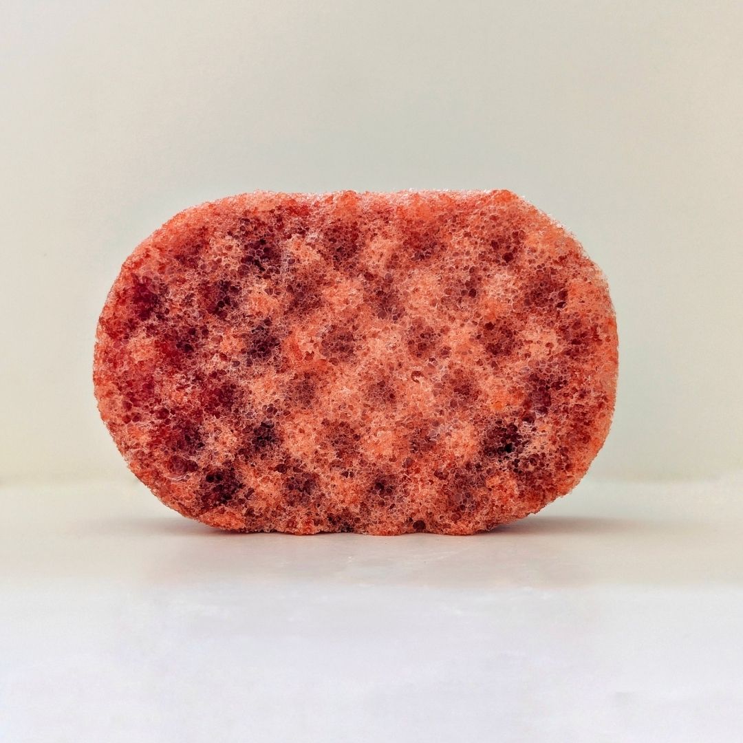 A textured dark orange sponge, filled with soap.