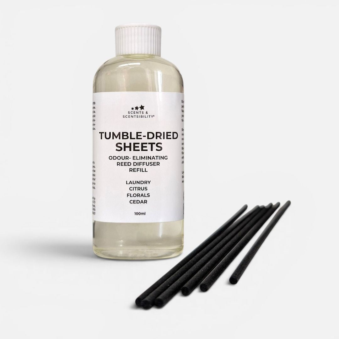 Bottle of 'Tumble-Dried Sheets' reed diffuser refill with black reeds on a white background