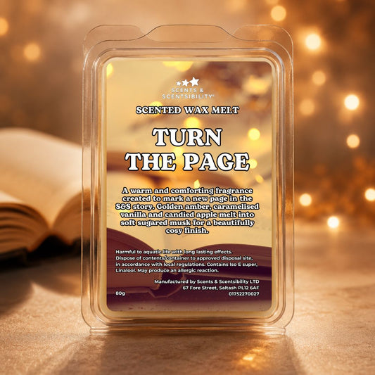 A clear plastic clamshell package of Scents & Scentsibility 'Turn The Page' scented wax melt, set against a warm, golden bokeh background with a blurred book on the left.