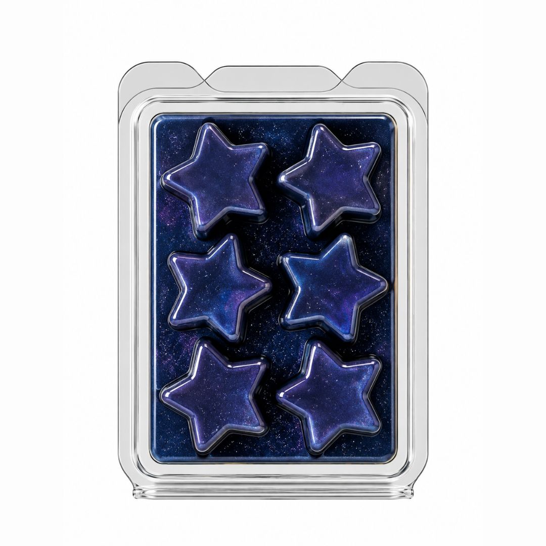 A clear plastic clamshell package containing five star-shaped wax melts with a deep blue galaxy pattern, set against a plain white background.