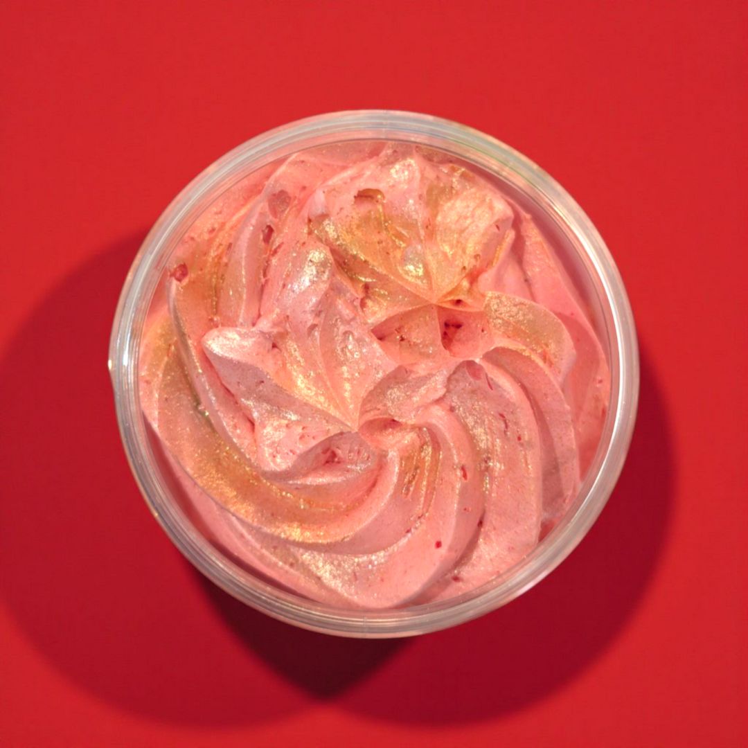 Red whipped cream with gold flakes in a container on a red background