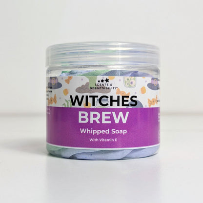 Jar of 'Witches Brew' whipped soap with a colorful label on a white background