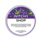 A round tub of Scents & Scentsibility 'Witchy Shop' scented wax melt, featuring a purple label with a green witch, orange flowers, and black spiders, set against a plain white background.