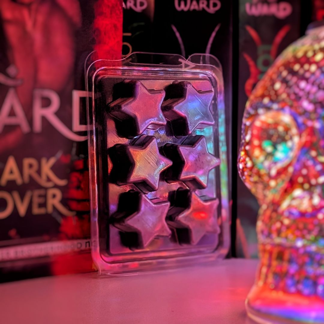 A black wax melt in a star-shaped clamshell