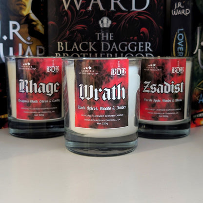 Three scented candles labeled 'Rhage', 'Wrath', and 'Zsadist' on a white surface with books in the background.