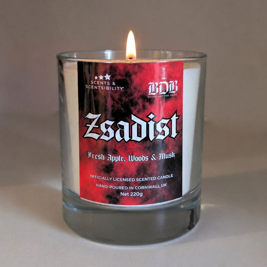 Candle with a red label featuring the word 'Zsadist' on a neutral background